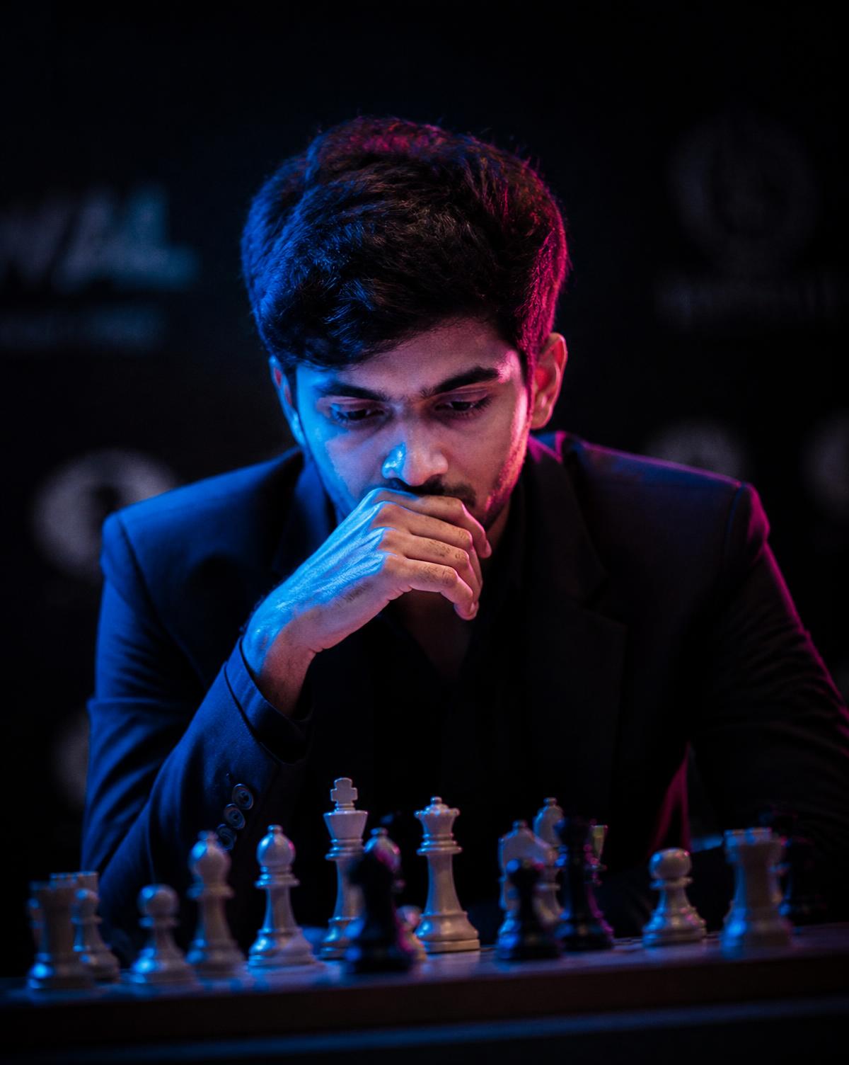 Focused chess player lit in blue and magenta